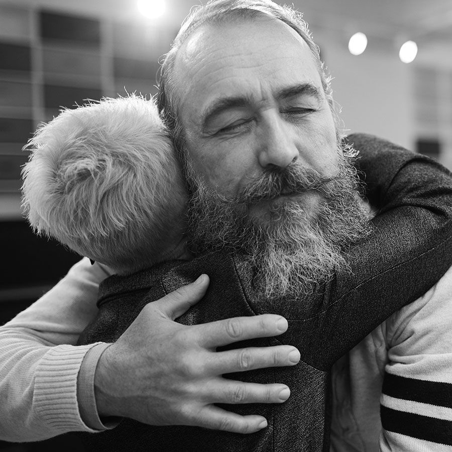 bearded older man hugging a short-haired woman