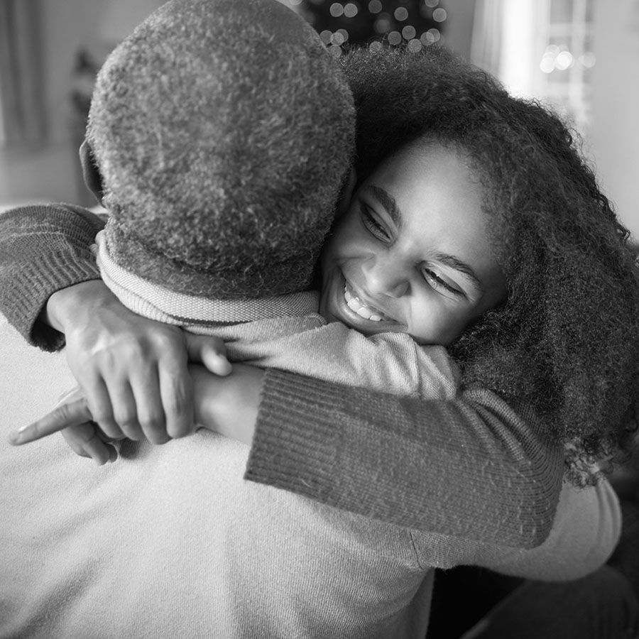 young african american girl hugging a senior man